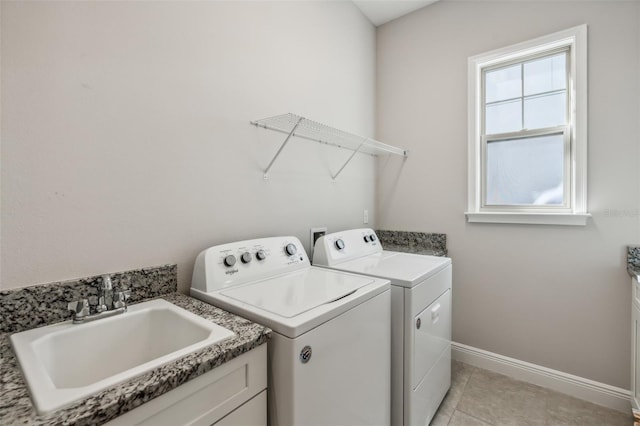 clothes washing area featuring light tile patterned floors, separate washer and dryer, and sink