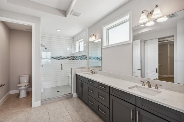 bathroom with tile patterned flooring, vanity, a shower with door, and toilet