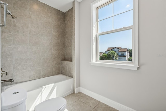 bathroom with tile patterned flooring, tiled shower / bath combo, and toilet