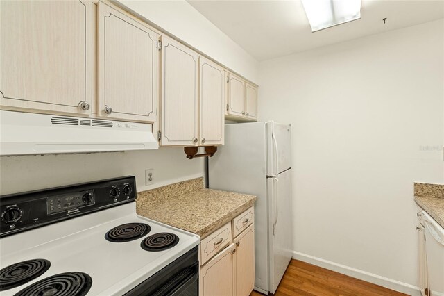 kitchen featuring white appliances and light hardwood / wood-style flooring