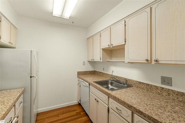 kitchen featuring dark hardwood / wood-style floors, white appliances, sink, and cream cabinets