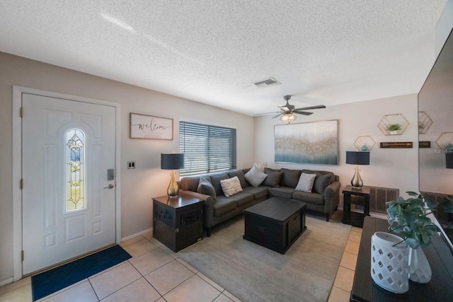 tiled living room featuring ceiling fan and a textured ceiling