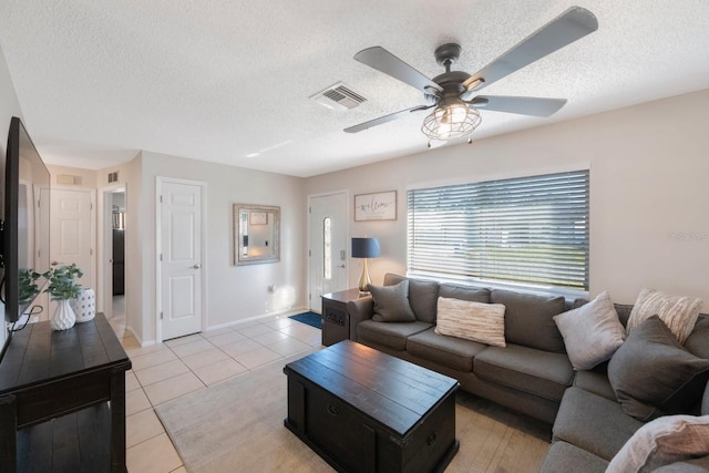 tiled living room featuring ceiling fan and a textured ceiling