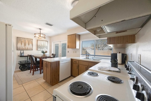 kitchen featuring kitchen peninsula, white appliances, sink, exhaust hood, and decorative light fixtures