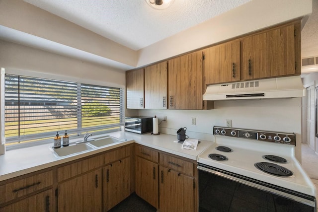 kitchen with electric stove, sink, and a textured ceiling