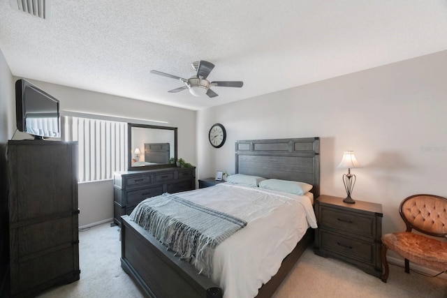 carpeted bedroom with ceiling fan and a textured ceiling