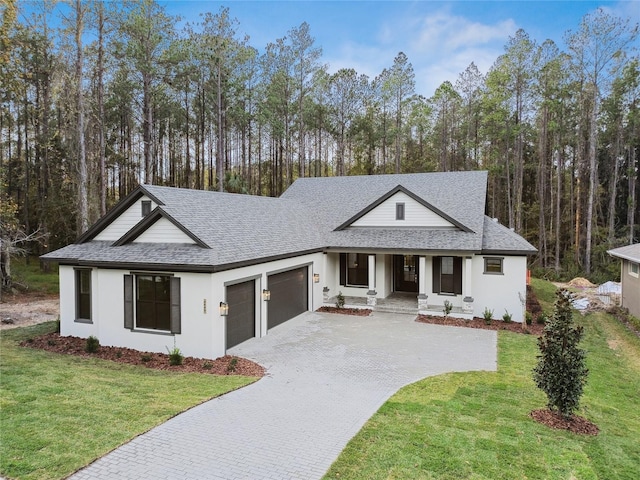 view of front of house featuring a porch, a garage, and a front yard