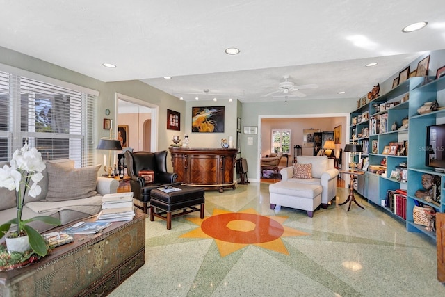 living room featuring ceiling fan and a textured ceiling