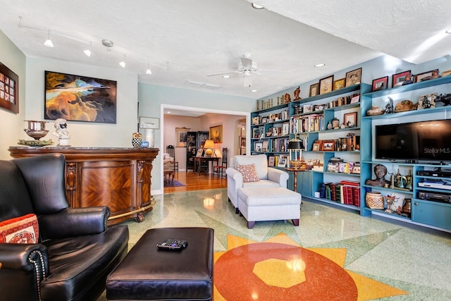 living room featuring bar, a textured ceiling, and ceiling fan