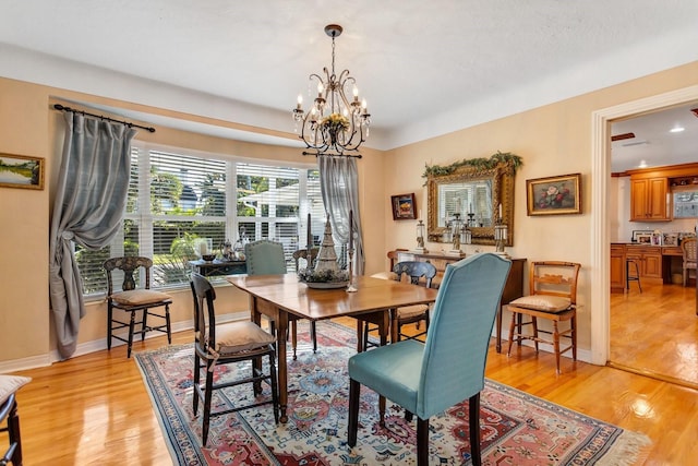 dining space with a notable chandelier and light hardwood / wood-style flooring