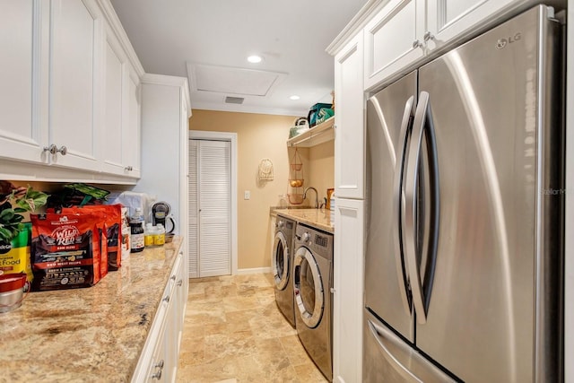 washroom with washer and clothes dryer, cabinets, and ornamental molding