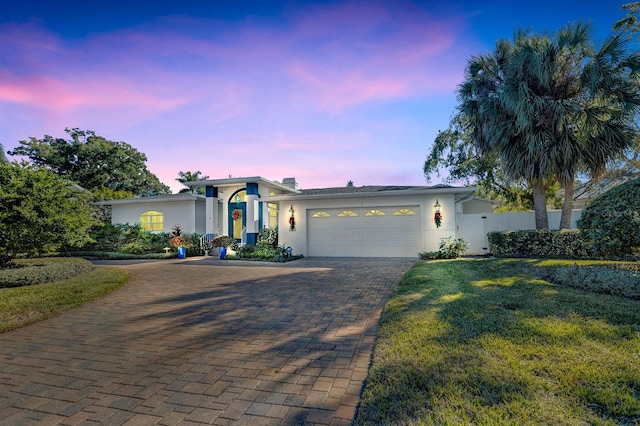 view of front of property featuring a lawn and a garage