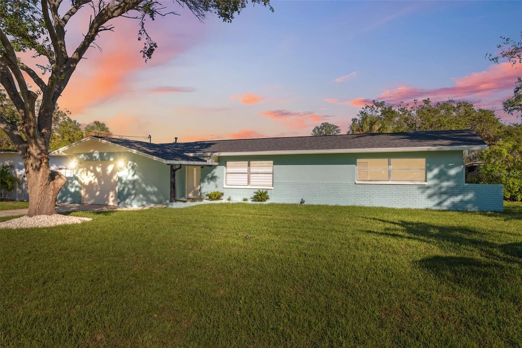 ranch-style house with a front yard and brick siding