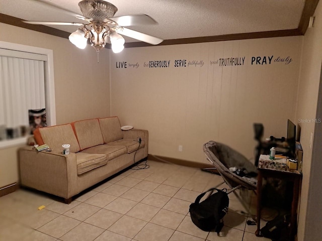 living room with ceiling fan, light tile patterned floors, a textured ceiling, and ornamental molding