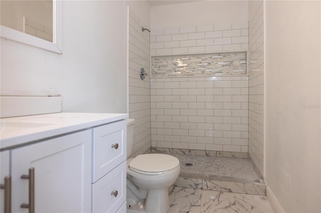 bathroom with vanity, toilet, and tiled shower