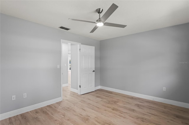 spare room with visible vents, ceiling fan, light wood-style flooring, and baseboards