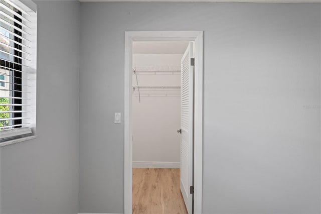 hall with baseboards and light wood-style flooring