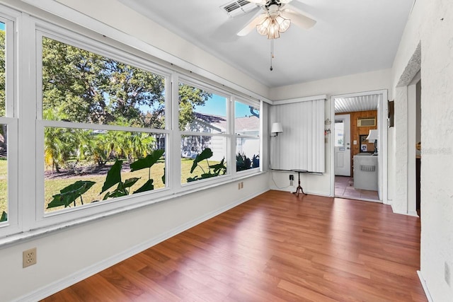 unfurnished sunroom with ceiling fan