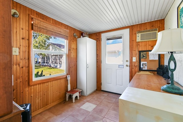 entryway with a wall mounted AC, wooden walls, and light tile patterned flooring