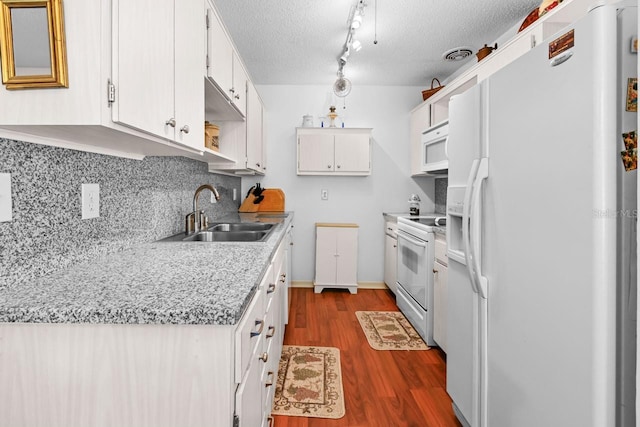 kitchen with dark hardwood / wood-style flooring, white cabinetry, sink, and white appliances