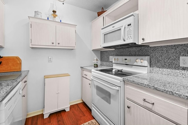 kitchen with white appliances, dark hardwood / wood-style floors, a textured ceiling, tasteful backsplash, and light stone counters