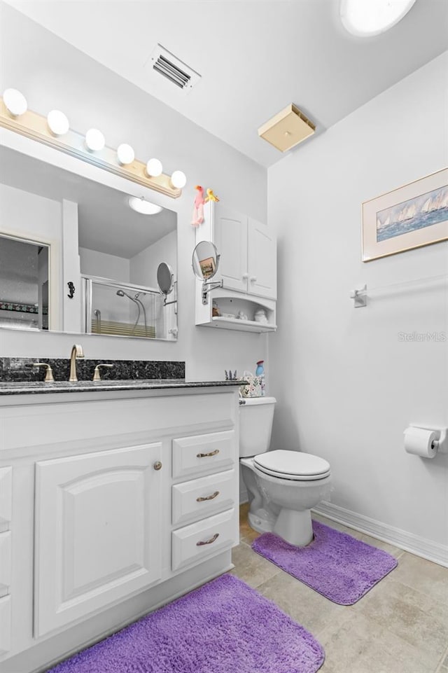 bathroom with tile patterned flooring, vanity, toilet, and a shower with door