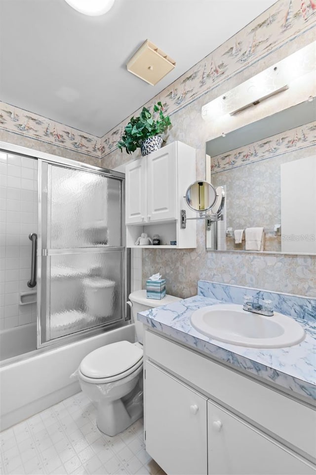 full bathroom featuring vanity, toilet, and combined bath / shower with glass door