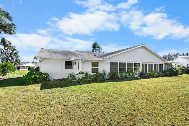 rear view of property featuring a yard