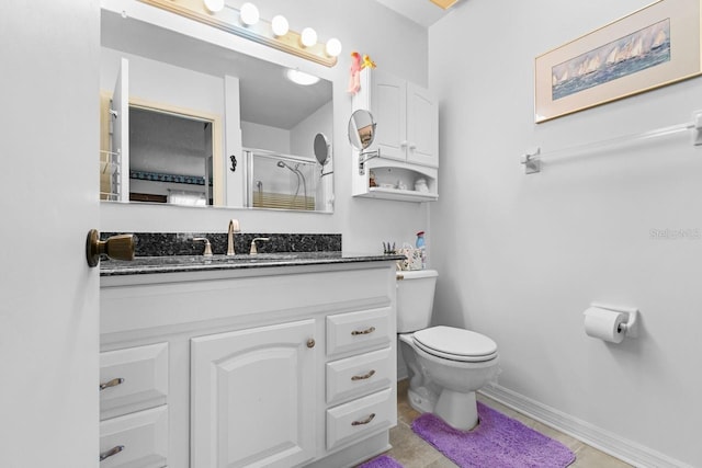 bathroom featuring tile patterned flooring, vanity, a shower with shower door, and toilet