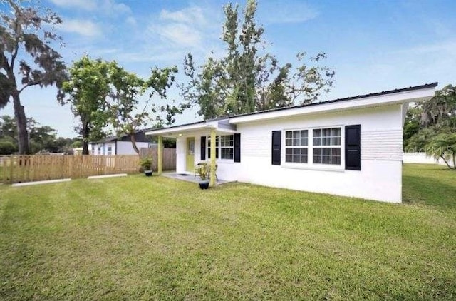 rear view of property with a lawn