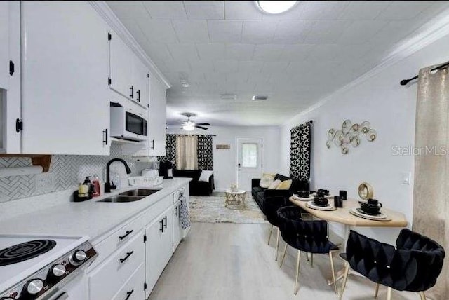 kitchen featuring white cabinets, light hardwood / wood-style floors, white appliances, and sink