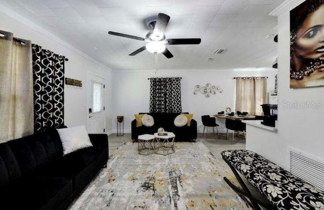 living room with plenty of natural light, ornamental molding, and ceiling fan