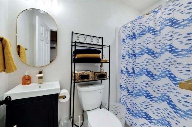 bathroom featuring vanity, a shower with shower curtain, and toilet