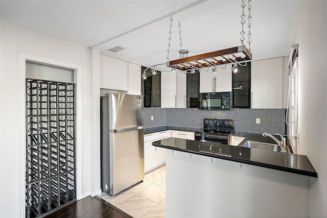 kitchen featuring kitchen peninsula, appliances with stainless steel finishes, tasteful backsplash, sink, and white cabinets