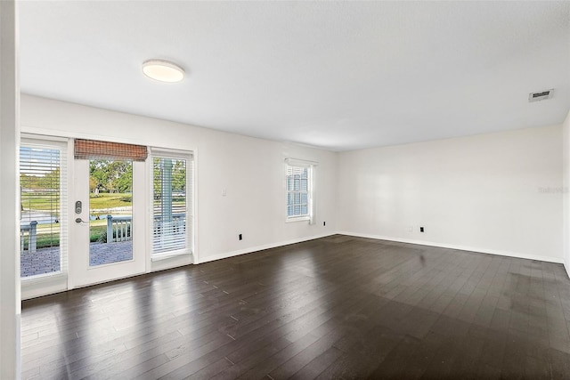 unfurnished room with a wealth of natural light and dark wood-type flooring