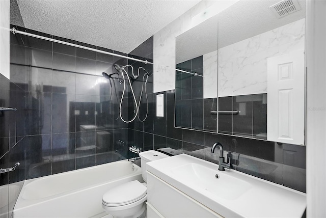 full bathroom with decorative backsplash, tiled shower / bath combo, toilet, a textured ceiling, and tile walls