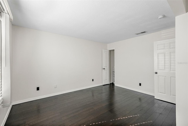 unfurnished room with dark hardwood / wood-style floors and a textured ceiling