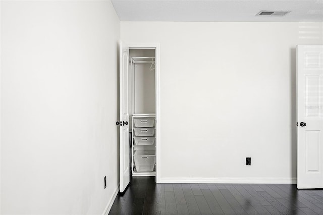 unfurnished bedroom featuring dark hardwood / wood-style flooring and a closet