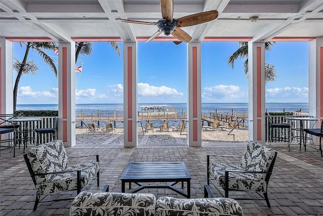 view of patio / terrace featuring outdoor lounge area, ceiling fan, a water view, and exterior bar