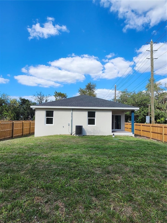 rear view of property with a yard, a fenced backyard, and stucco siding