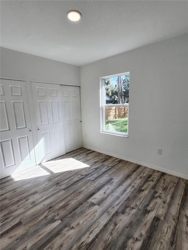 unfurnished bedroom with a closet and dark wood-type flooring