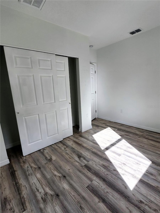 5714 Olive Dr, New Port Richey, FL 34652 - unfurnished bedroom with a closet, wood finished floors, and baseboards