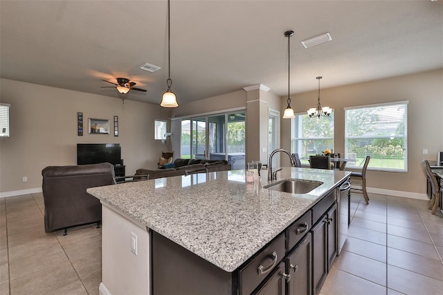 kitchen featuring ceiling fan with notable chandelier, dishwasher, sink, and an island with sink