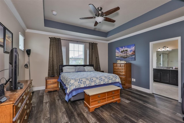 bedroom featuring ceiling fan, dark wood-type flooring, ensuite bathroom, a tray ceiling, and ornamental molding