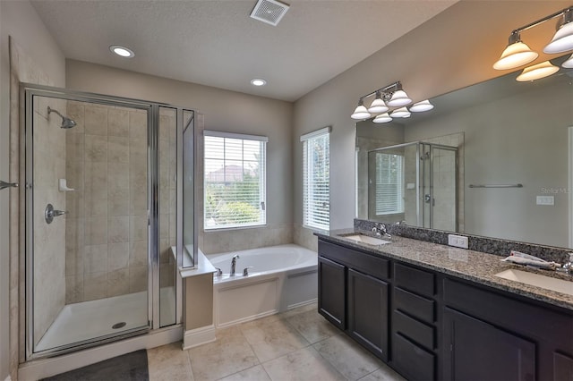 bathroom with tile patterned flooring, vanity, separate shower and tub, and a textured ceiling