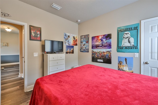 bedroom with a textured ceiling and dark wood-type flooring