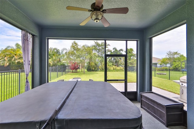 unfurnished sunroom featuring ceiling fan