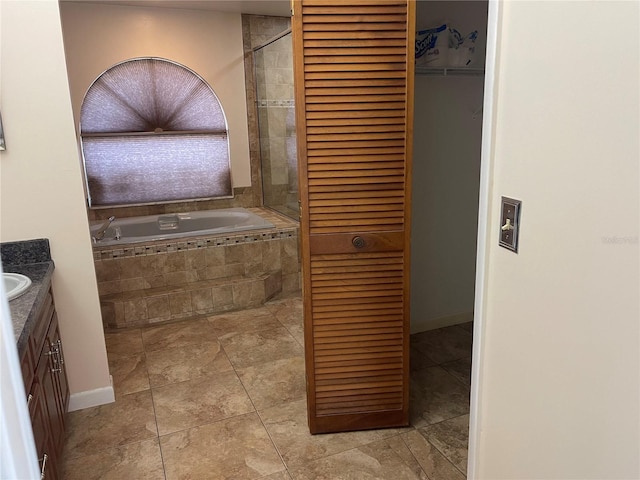 bathroom with a relaxing tiled tub and vanity