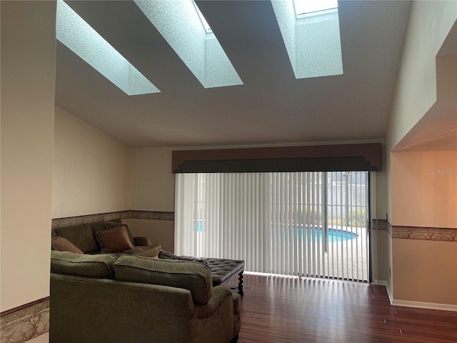 living room featuring hardwood / wood-style floors and vaulted ceiling with skylight