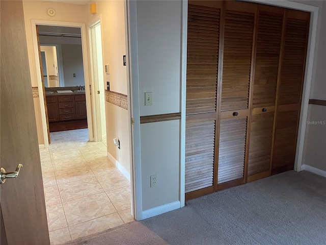 corridor with sink and light carpet